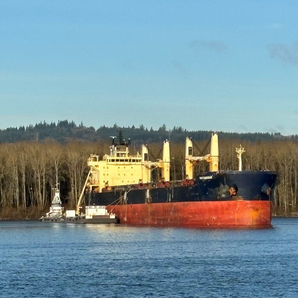 Image of a ship with a barge alongside